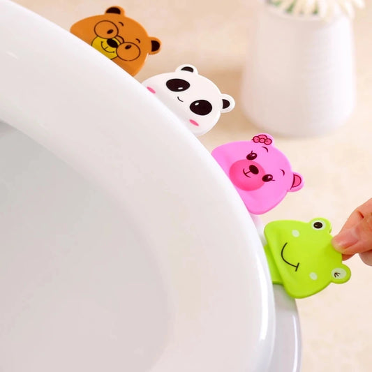 Set of colorful animal-themed toilet seat lifters, including frog, bear, and panda designs, attached to a toilet seat for hygienic lifting.