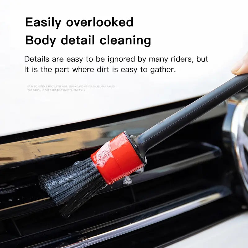 Car detailing brush cleaning a vehicle's front grille, showcasing its ability to reach overlooked areas where dirt and grime accumulate.