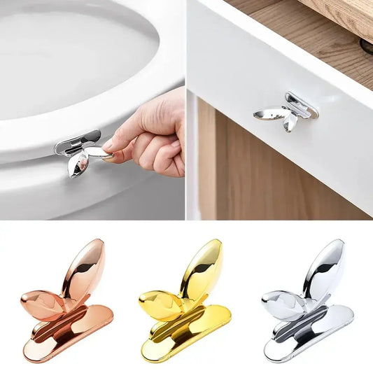 Hands-free toilet seat lifter handle in butterfly design, available in gold, silver, and rose gold. Easy installation for hygienic toilet use.